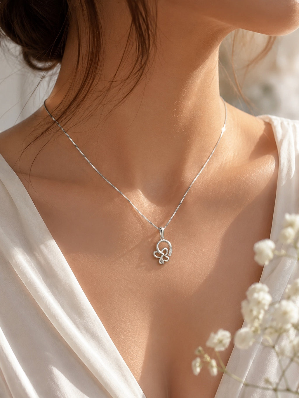 Close-up of a model wearing a 10K white gold butterfly pendant necklace featuring 0.73 carat natural diamonds on a fine box chain, elegant everyday fine jewelry.