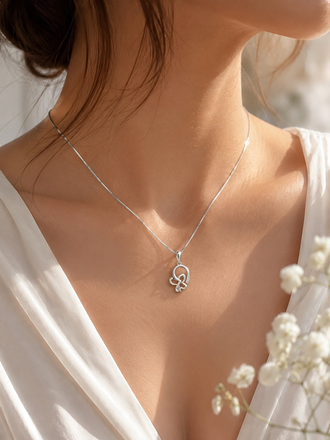 Close-up of a model wearing a 10K white gold butterfly pendant necklace featuring 0.73 carat natural diamonds on a fine box chain, elegant everyday fine jewelry.