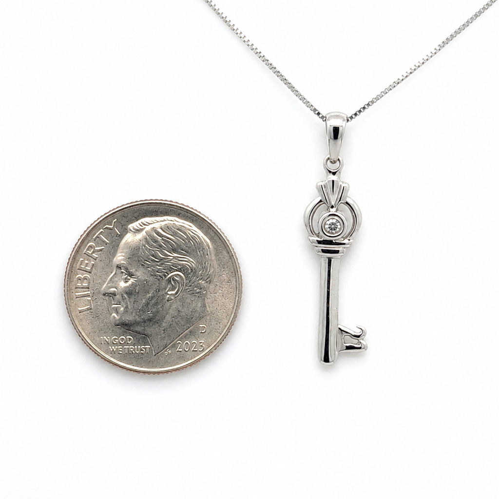 10K white gold key pendant necklace with 0.86 CTW diamonds shown next to a U.S. dime for size reference.