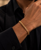 14K yellow gold men's Byzantine chain bracelet featuring intricate interwoven links, worn on a man's wrist with a black shirt.