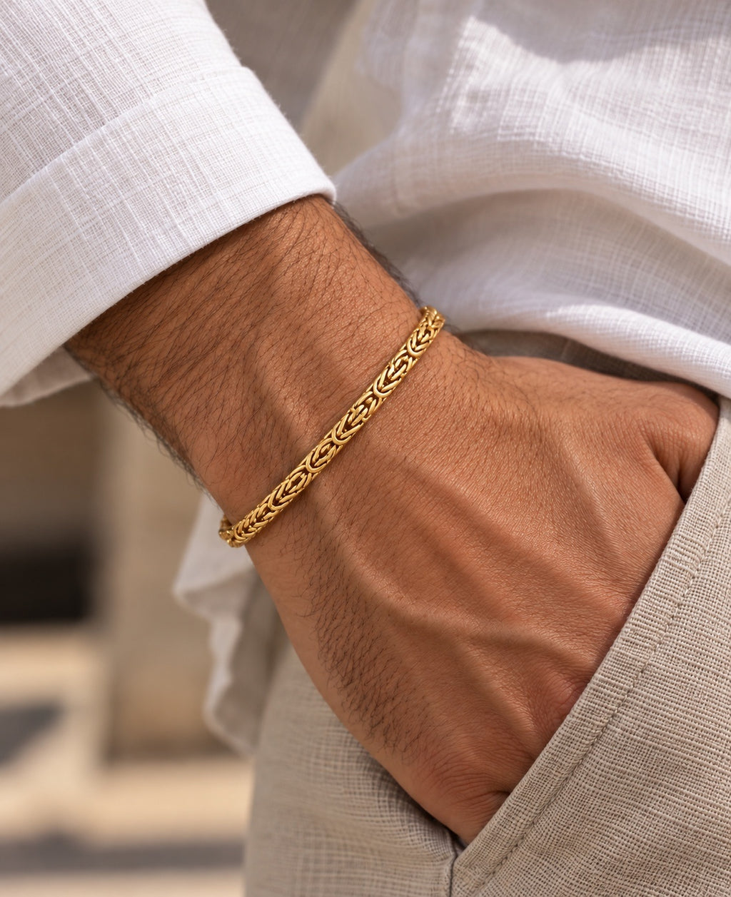 14K yellow gold men's Byzantine chain bracelet with intricate woven links, shown on a man's wrist with a white shirt.