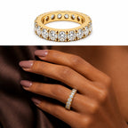 18K yellow gold eternity band featuring 3.75 carats total weight of round brilliant diamonds, shown in a studio product image and elegantly worn on a woman’s finger.