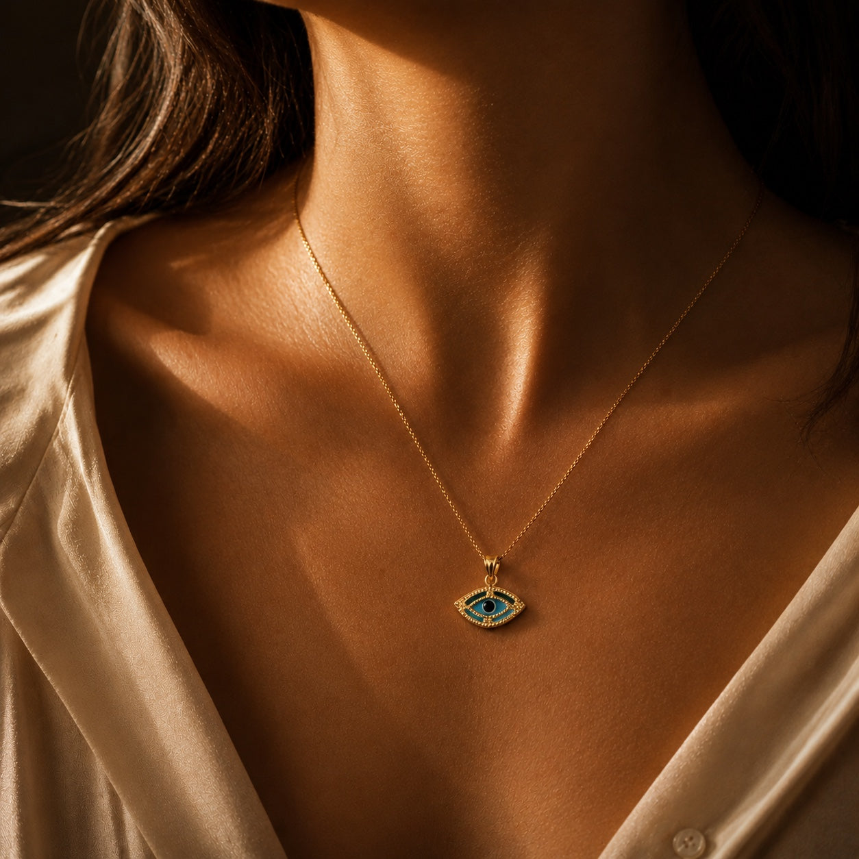 Model wearing a 14K gold evil eye necklace with blue enamel pendant, luxury fine jewelry styling and everyday elegance