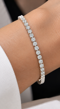 Elegant round brilliant diamond tennis bracelet in white gold worn on a woman’s wrist, showcasing sparkling diamonds and timeless luxury jewelry by La Noosha.