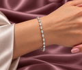 Delicate Emerald Cut Lab-Grown Diamond Tennis Bracelet in White Gold with Spaced Diamond Settings on Woman's Wrist – La Noosha Jewelry