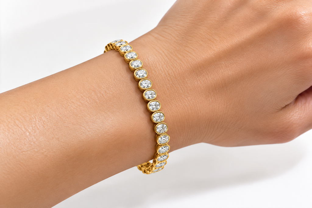 Oval Cut Lab-Grown Diamond Tennis Bracelet in Yellow Gold with Bezel Settings Worn on Woman's Wrist – La Noosha Jewelry