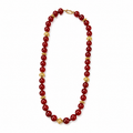 Red beaded necklace with gold accents on a white background