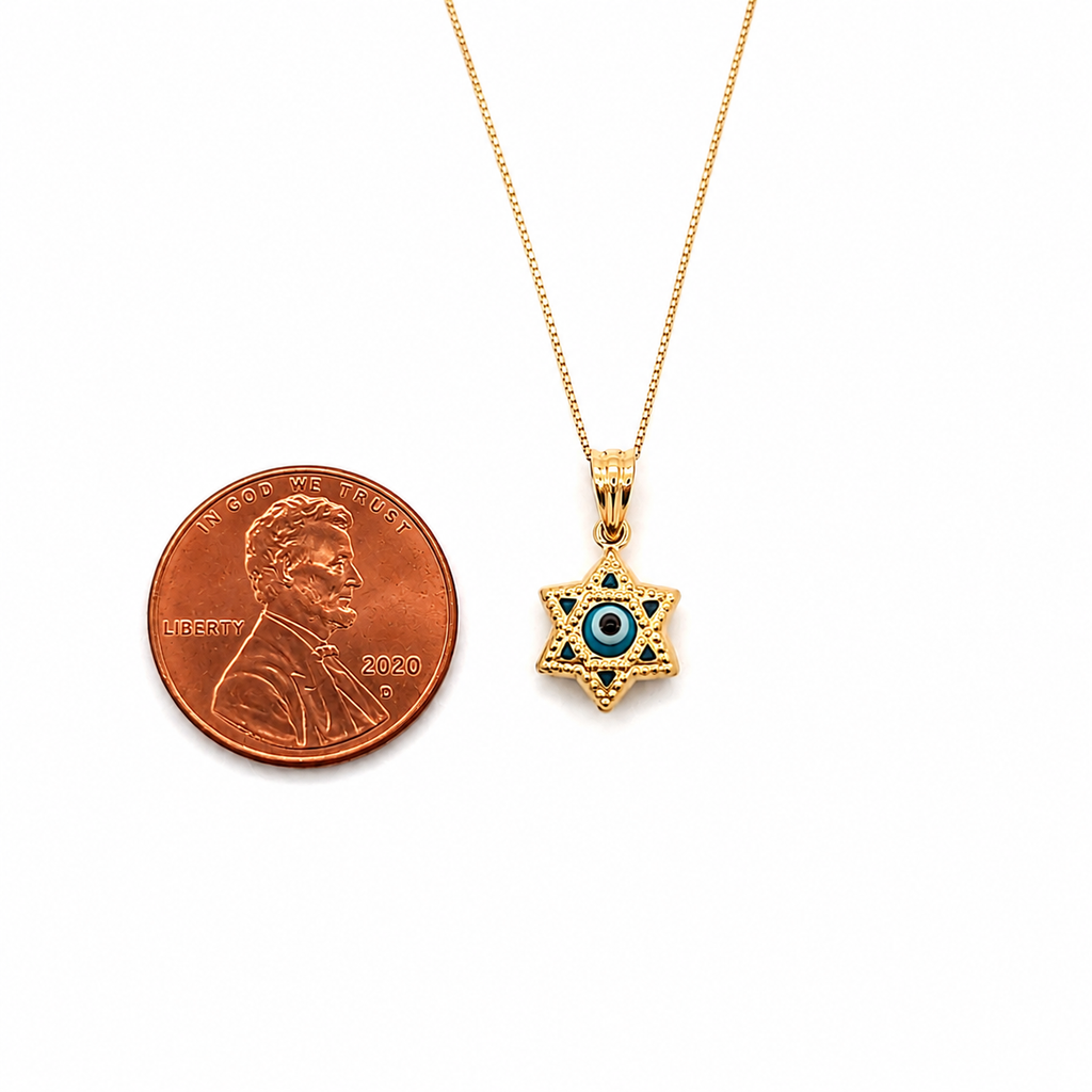14K gold Star of David evil eye pendant necklace with blue enamel shown beside a U.S. penny for size comparison