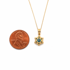 14K gold Star of David evil eye pendant necklace with blue enamel shown beside a U.S. penny for size comparison