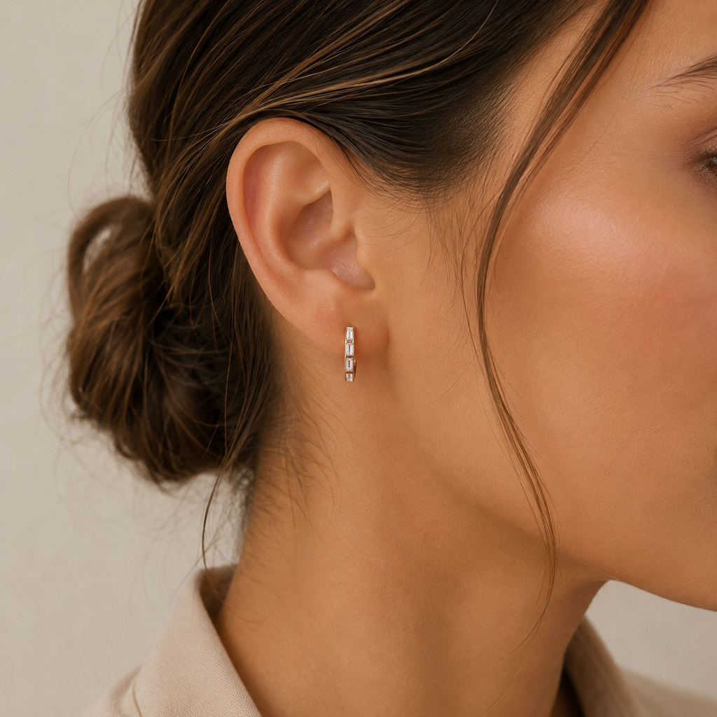 Model wearing 18K yellow gold baguette diamond huggie earrings featuring 0.288 CT natural diamonds in a sleek geometric design
