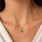 Model wearing a 14K gold evil eye necklace with blue eye pendant on a delicate box chain.