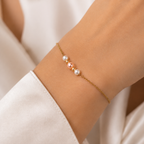 Woman wearing a 14K gold pearl bracelet with white and blush freshwater pearls styled on the wrist