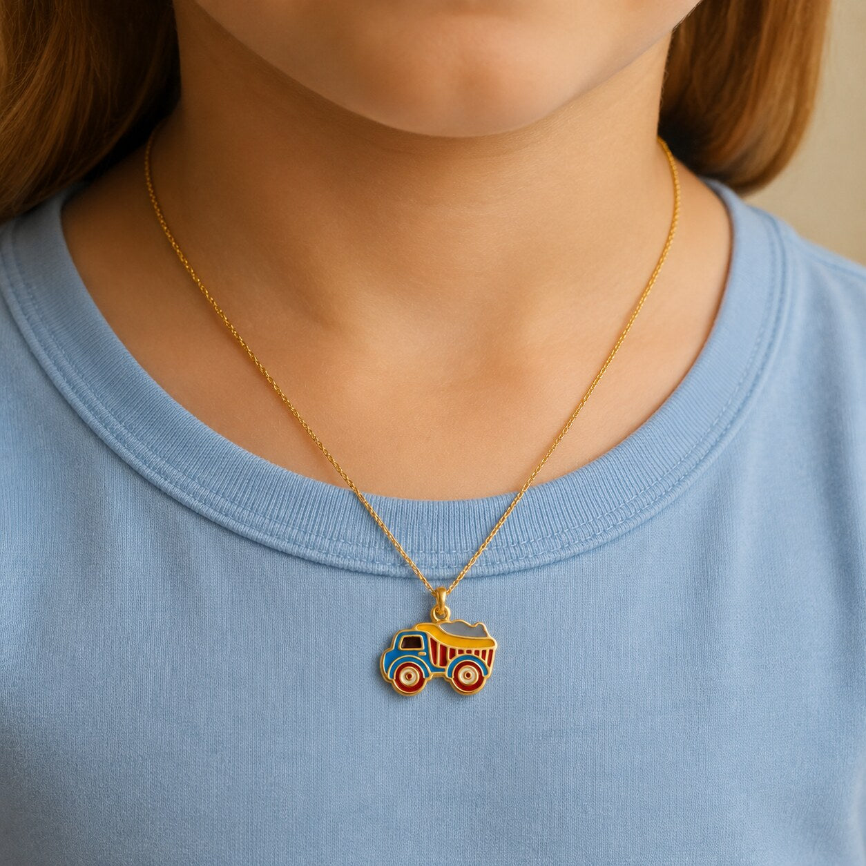Child wearing a small colorful gold dump truck pendant