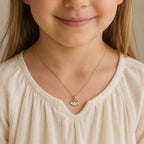 Child wearing a gold smiling cloud pendant with colorful flowers