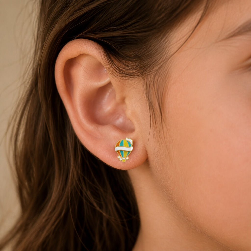 Child wearing a small colorful yellow gold hot air balloon stud earring