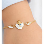 Petite yellow gold guardian angel bracelet worn on a child’s wrist