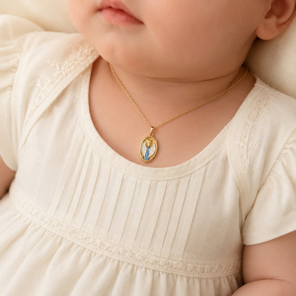 Petite yellow gold guardian angel pendant styled on an infant model