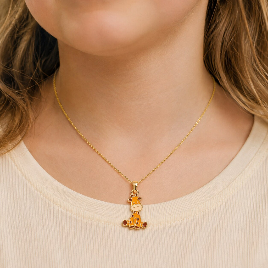 Child wearing a small yellow gold colorful giraffe pendant on a delicate chain