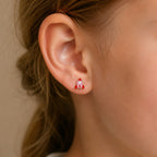 Child wearing a small yellow gold pink rocket stud earring
