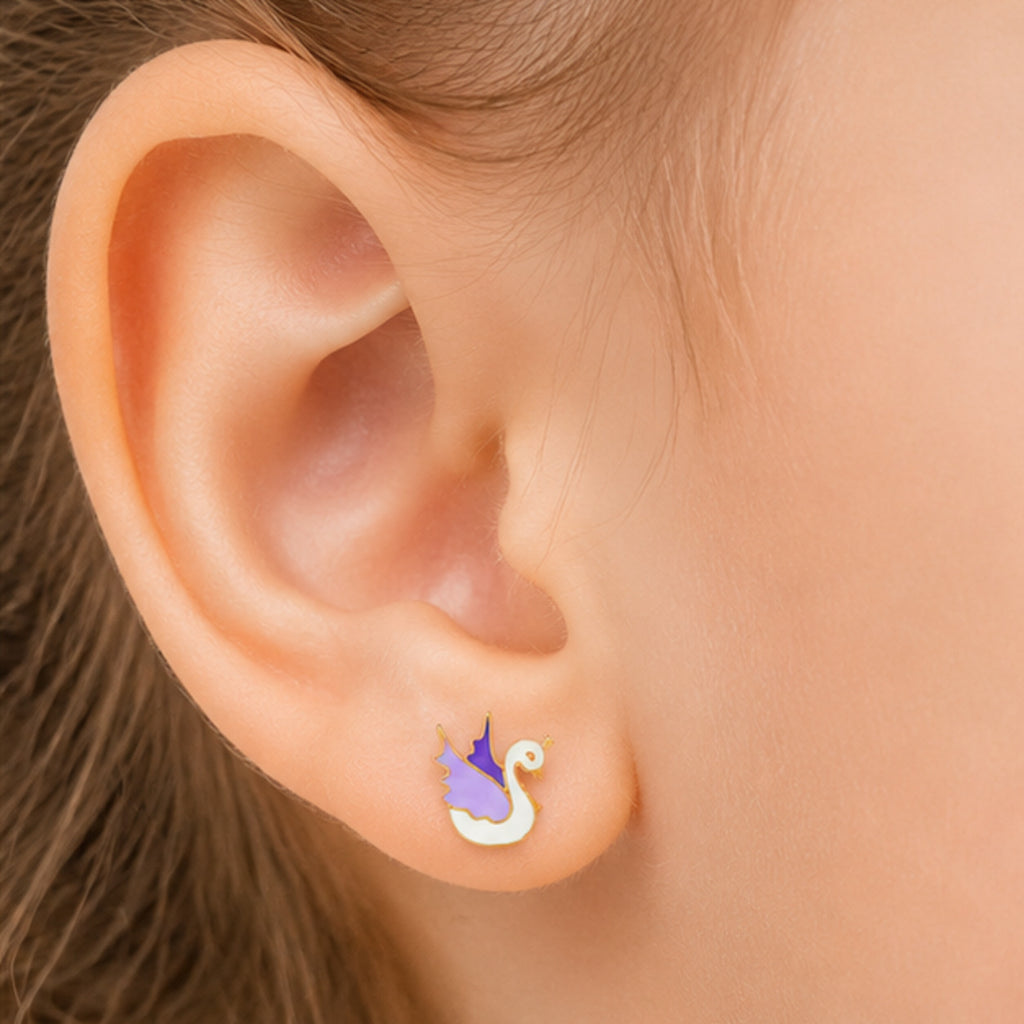Child wearing a small yellow gold white and purple swan stud earring