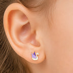 Child wearing a small yellow gold white and purple swan stud earring