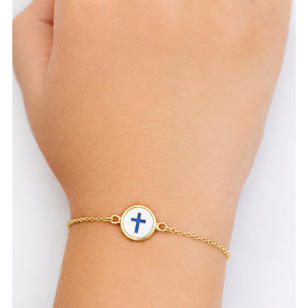 Child wearing a petite yellow gold reversible cross bracelet