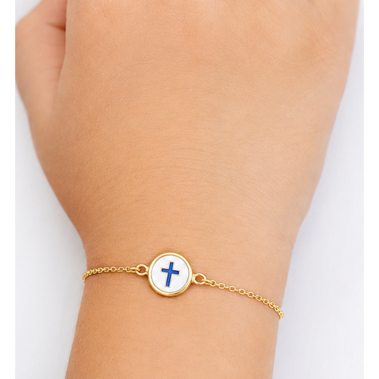 Child wearing a petite yellow gold reversible cross bracelet