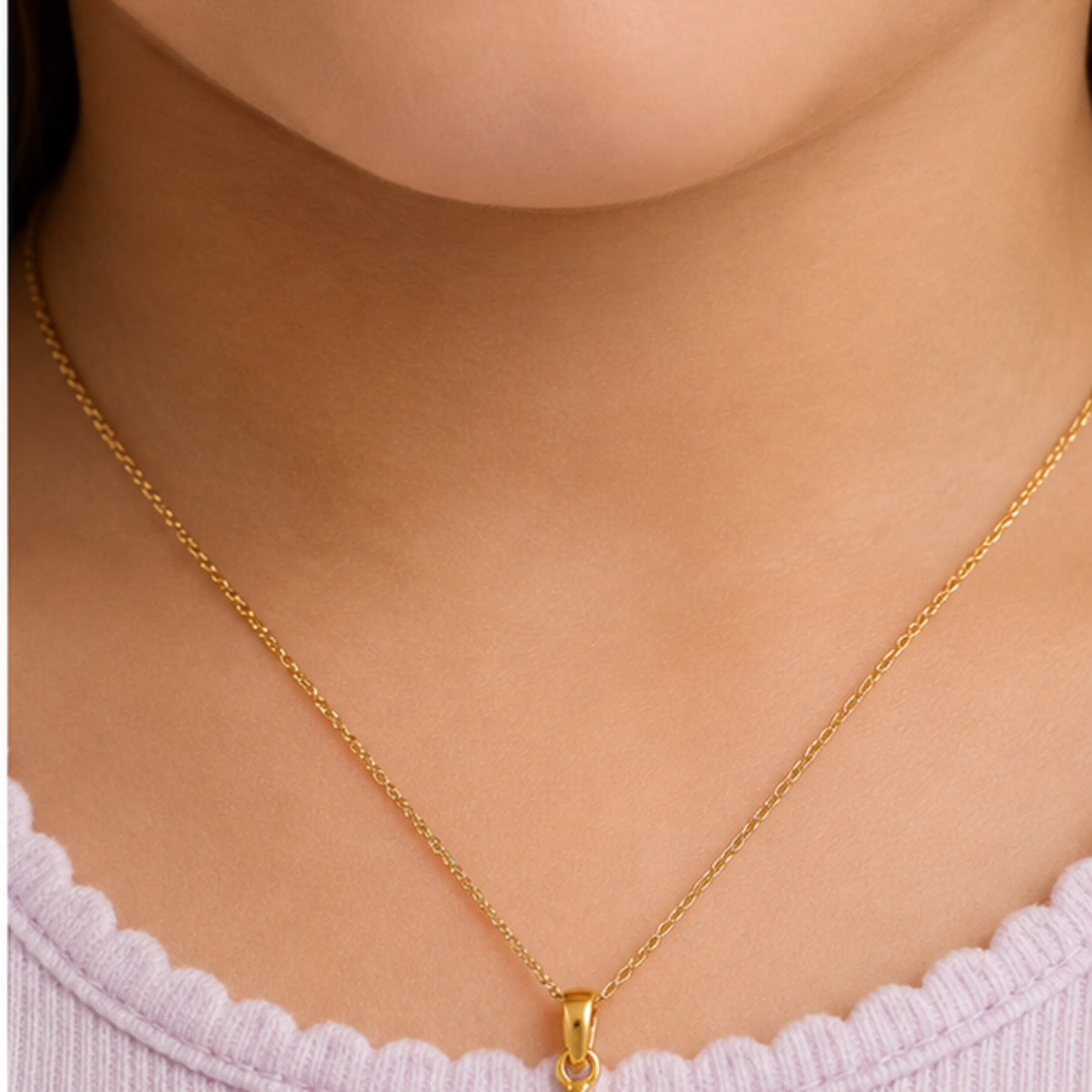 Child wearing a small yellow gold multicolor smiling sun pendant
